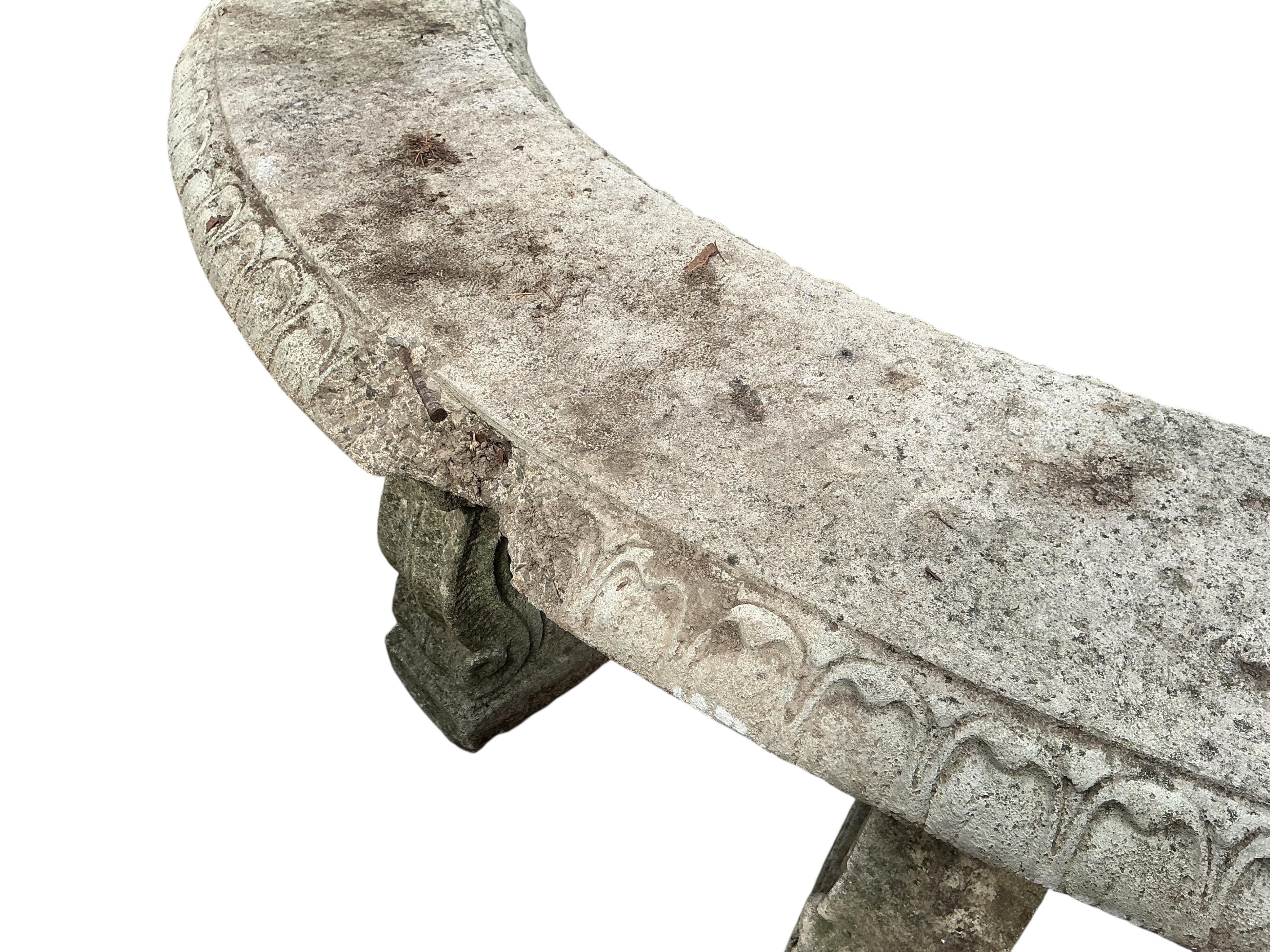 A reconstituted stone curved garden bench, width 134cm, height 44cm